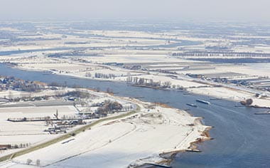An aerial view of the Rhine river in winter, with a light dusting of snow